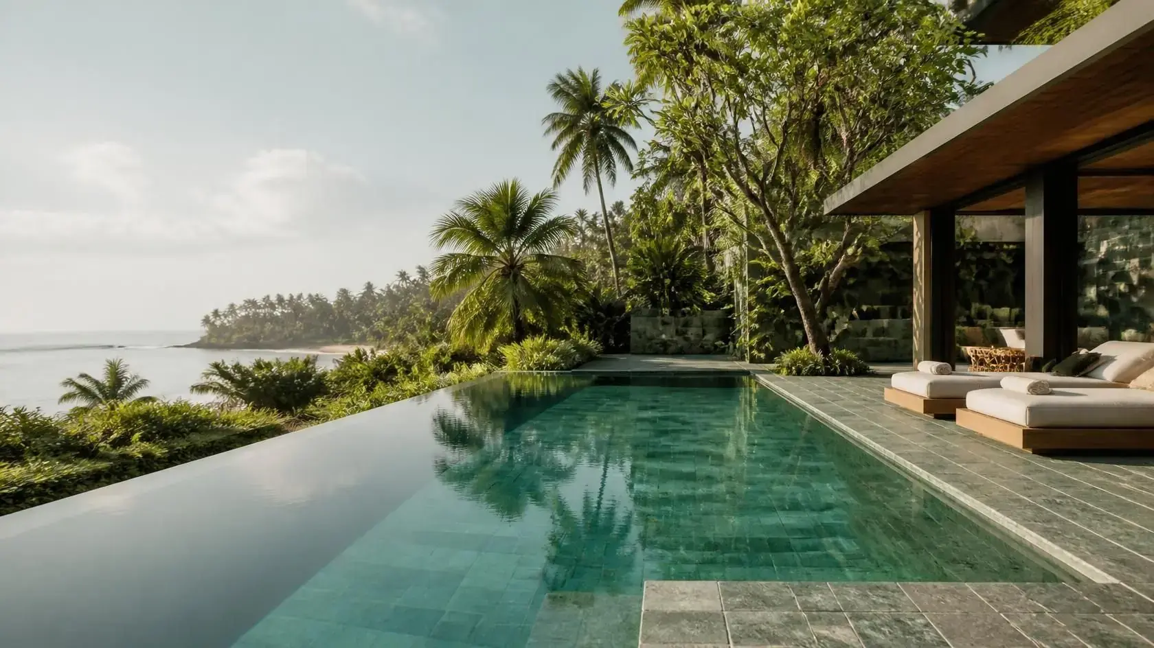 Piscina de borda infinita revestida com Pedra Hijau em uma villa tropical